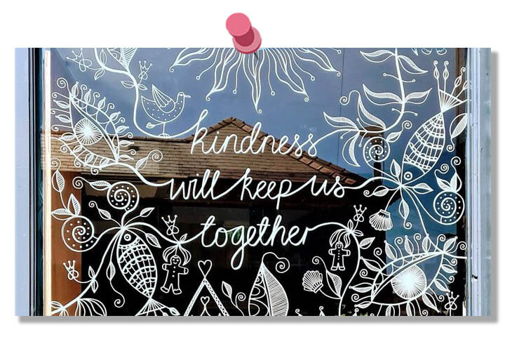 Intricate hand drawn, white line art. Floral patterns, birds and gingerbread people. Words read, Kindness will keep us together.